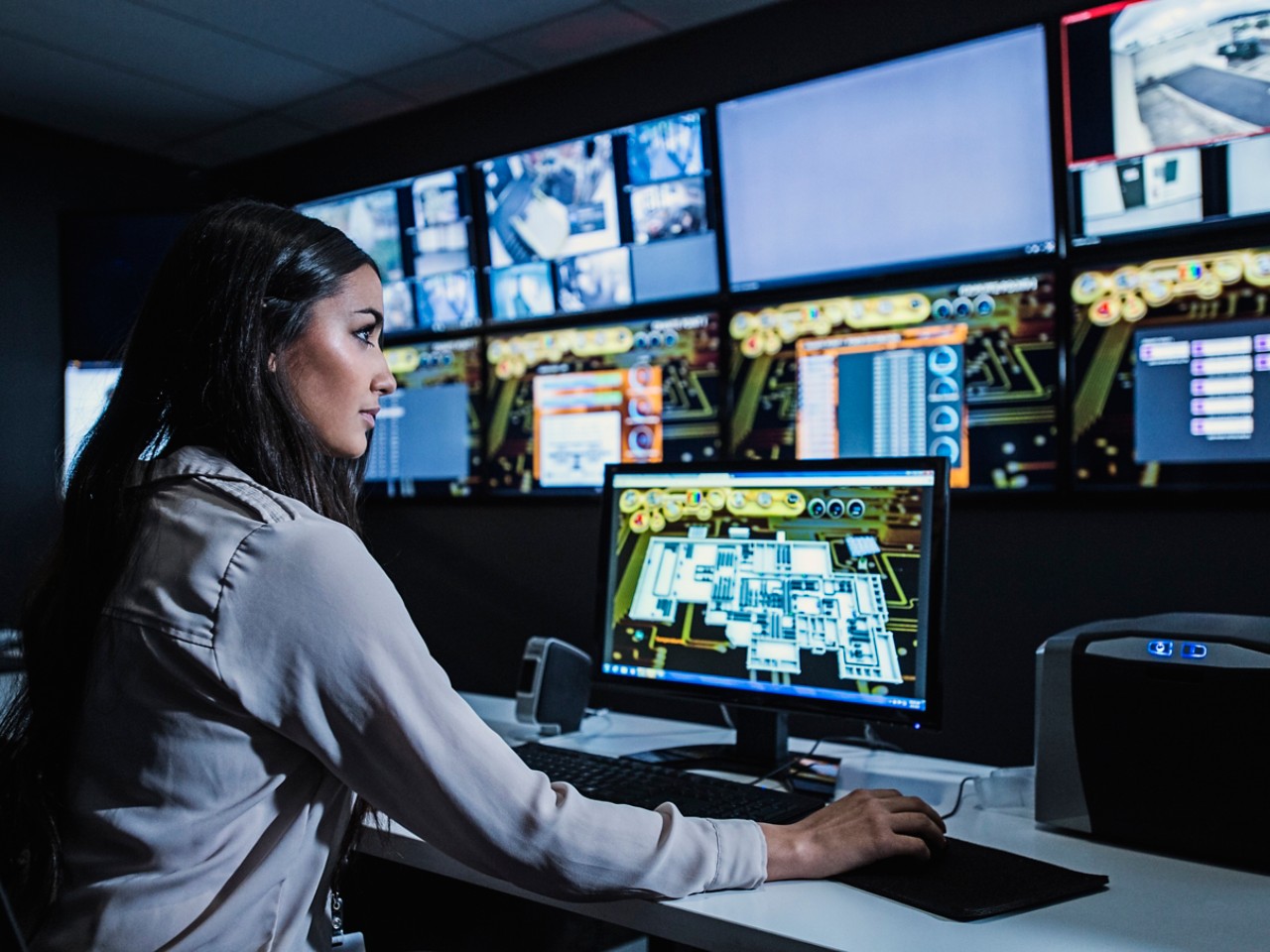 Woman-sitting-at-computer-monitors-in-a-control-room.jpg