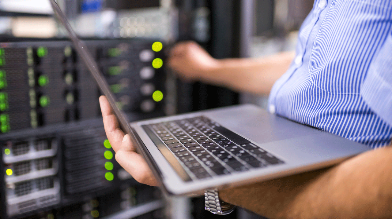 IT-engineer-holding-laptop-near-servers-close-up.png